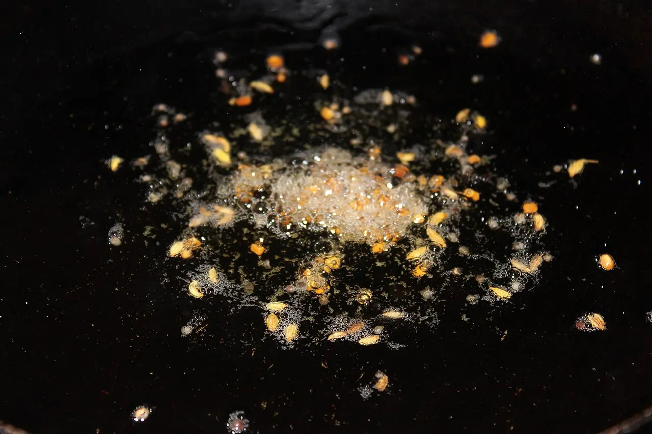 panch phoron tempering in hot oil, seeds visible